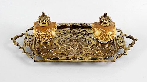 A brass and porcelain desk stand, having mask and acanthus cast rectangular tray within a pierced bo