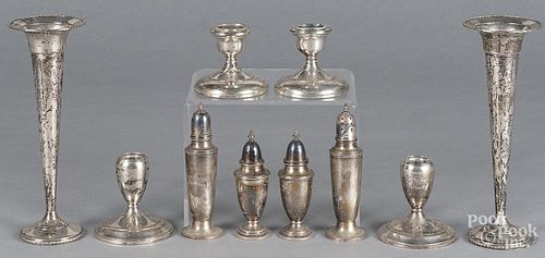 Weighted sterling silver candlesticks, together with vases and shakers.
