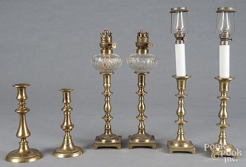 Pair of English brass candlesticks fitted with glass fonts, 15'' h., together with four other sticks.