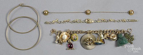 Assorted yellow gold bracelets, to include a 14K charm bracelet with various charms, 7'' l.