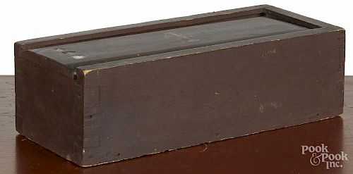Painted pine slide lid candlebox, 19th c., retaining an old dark red surface, 4 1/2'' h., 16'' w.