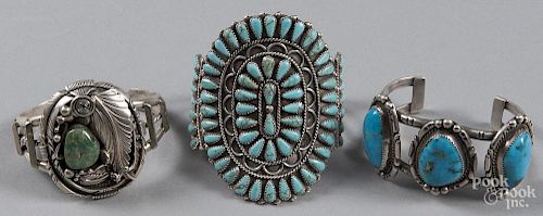 Three Navajo silver and turquoise cuff bracelets.