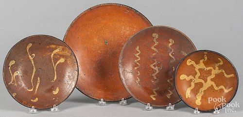 Four Pennsylvania redware plates, 19th c., three with yellow slip decoration, 6 1/4'' - 10 3/4'' dia.