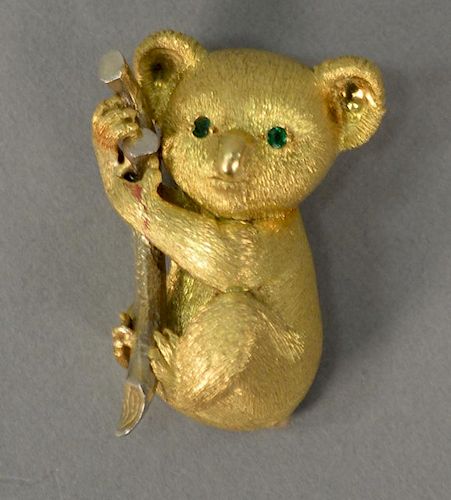 18K gold koala bear brooch holding a telephone with emerald eyes. 
22.4 grams
