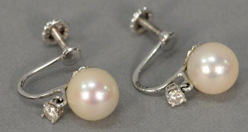 Pair of 14K white gold earrings set with pearls and small dangle diamonds (screw backs).