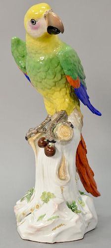 Large Meissen porcelain parrot having bright plumage perched on a floral decorated tree stump having blue crossed swords mark "A43A"...