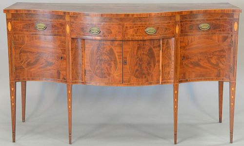 Federal mahogany sideboard having serpentine top over conforming case having three drawers over four doors all set on square tapered...