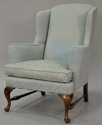 Custom Queen Anne style upholstered wing chair on cabriole legs ending in pad feet joined by block and turned stretchers. 
seat ht. ...