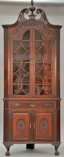 Custom mahogany corner china cabinet in two parts, upper portion with large finial and broken arch top over deep shell over two shap...