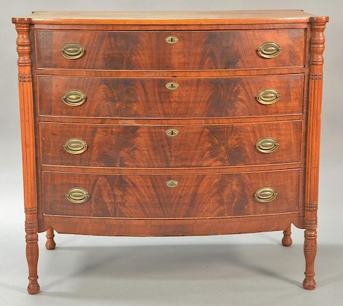 Sheraton bowed front chest with cookie corners and four drawers flanked by turned and fluted columns set on turned legs, circa 1830....