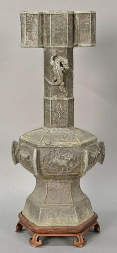 Large bronze archaic style dragon vase having molded dragon and foo lions in octagon form on carved wood base, 20th century.