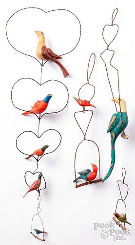 Group of carved and painted birds on wire perch