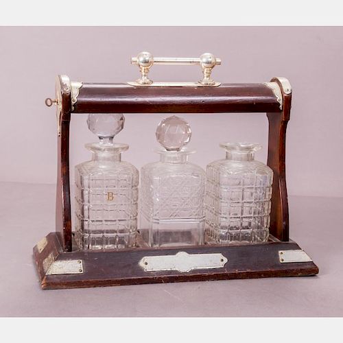 A Regency Style Brass and Mahogany Tantalus with Three Cut Glass Decanters, 19th/20th Century.