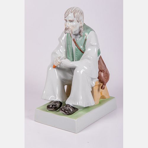 A Large Zsolnay Figure, Seated Man Whittling 
