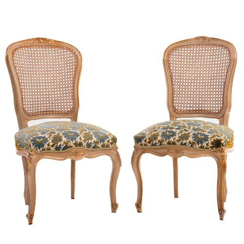 Par de sillas. SXX. Elaboradas en madera. Con respaldos de bejuco, asientos de tela florales y soportes tipo cabriolé.