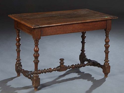 French Provincial Louis XIII Style Carved Oak Writing Table, 20th c., the rounded edge top over a long frieze drawer, on turned and block legs, joined