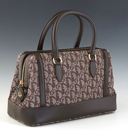 Dior Trotter Top Handle Handbag, in brown Diorissimo canvas with dark brown leather accents and gold hardware, opening to a dark green nylon interior 