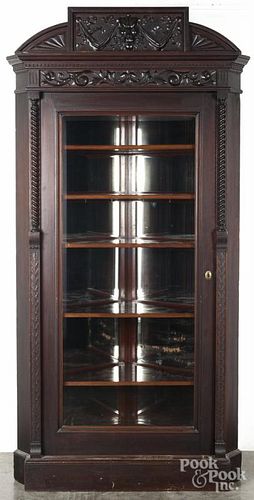 Victorian mahogany corner cupboard with a carved crest and mirrored back, 90'' h., 44'' w.