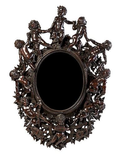 A Venetian Carved Walnut Mirror Height 39 1/2 x width 26 3/4 inches.