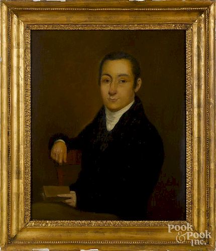 Oil on board portrait of a gentleman, 19th c., seated in a chair holding a book, 16'' x 13''.