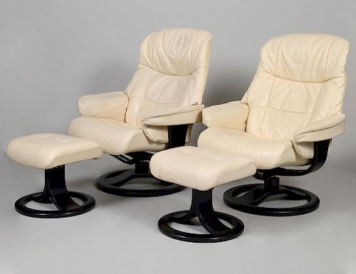 PAIR OF HJELLEGJERDE SWIVEL ARM CHAIRS AND FOOTSTOOLS