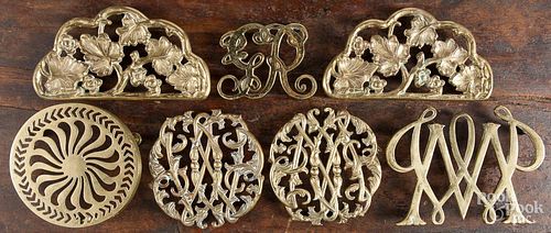 Seven cast brass trivets, 20th c., most Colonial Williamsburg.