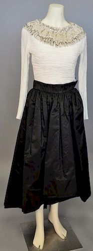 Mary McFadden, c. 1990s, Evening ensemble consisting of a black silk skirt with a dipped hemline, and a white crinkle-pleated silk bodice. The necklin