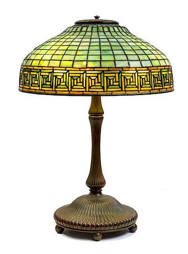 A Tiffany Studios Leaded Favrile Glass and Bronze Greek Key Table Lamp Height 23 x diameter of shade 16 inches.
