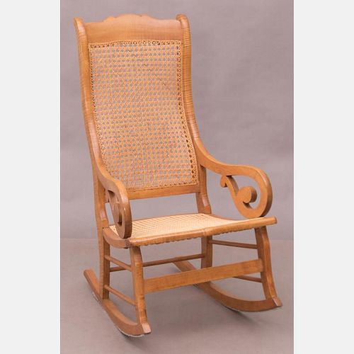 An American Walnut Rocking Chair with Caned Seat and Back, 19th Century.