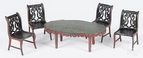 Painted cast iron doll table and four chairs.