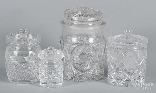 Four colorless glass lidded canisters, the smaller two marked Tudor and Waterford