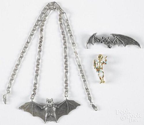 18K gold and enameled harlequin pin, 1 5/8'' h., together with two sterling silver flying bat pendant