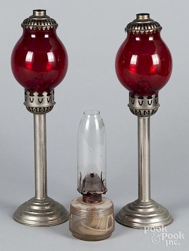 Pair of ruby glass and tin fluid lamps, 15 1/2'' h., together with a smaller lamp, 9'' h.