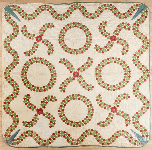 Appliqué quilt, late 19th c., with red and green X's and O's within a vine border, 75'' x 76''.