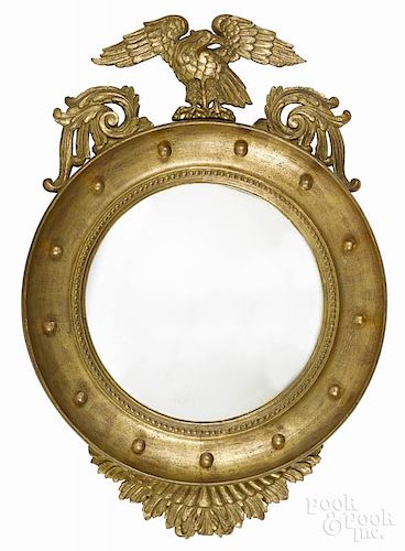 Giltwood convex mirror, early 20th c., with an eagle crest, 37'' h.