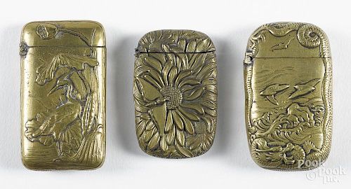 Three embossed brass match vesta safes, ca. 1900, one with an egret, one with a bee on a flower