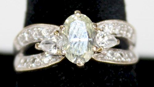 18k w.g. ladies diamond ring. Center oval cut diamond 7.2mm x 5.2mm x 3mm. Approx. _ct. Each side is