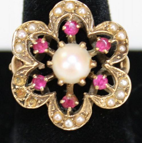 14k y.g. floral form ladies ring having center 7mm luster pearl. 6 sm round cut rubies and small see