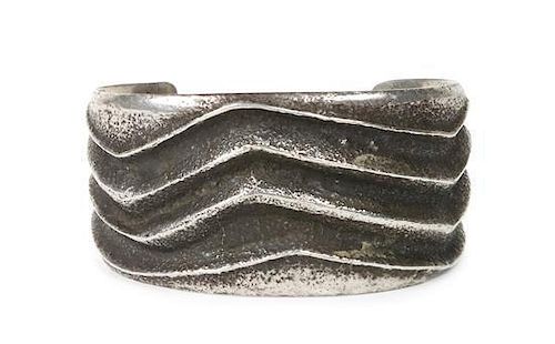 A Hopi Silver Tufa-Cast Bracelet, Charles Loloma, Length 5 1/4 x opening 1 3/8 x width 1 3/8 inches.