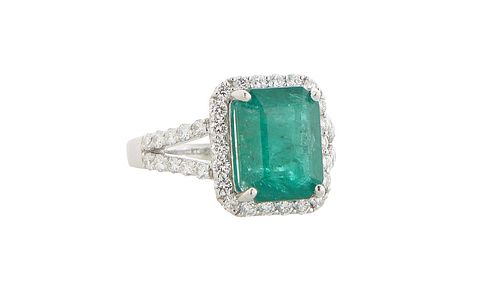 Lady's Platinum Dinner Ring, with a 4.79 ct. emerald atop a border of small round diamonds, the splits shoulders of the band also mounted with small r