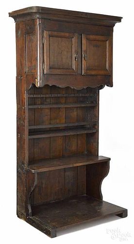 French oak wall cupboard, late 18th c., with a two-door upper section and a scalloped apron