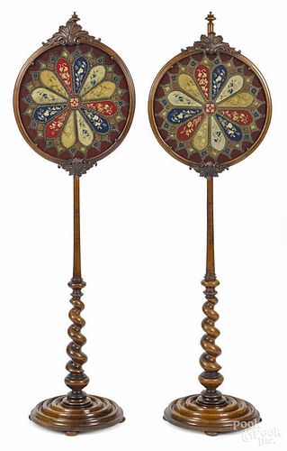 Pair of Continental carved walnut pole screens, mid 19th c., with needlework and beadwork panels