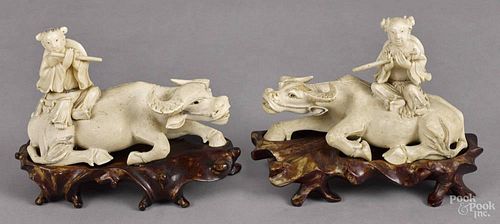 Pair of Chinese carved ivory groups of a woman, late 19th c., atop a water buffalo