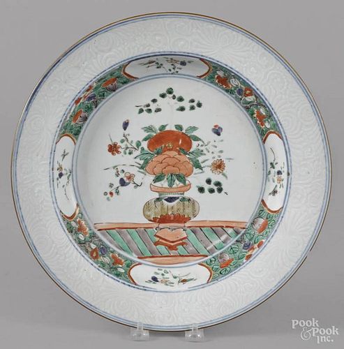 Chinese Qing dynasty Wucai porcelain charger with a central urn and bianco sopra bianco rim