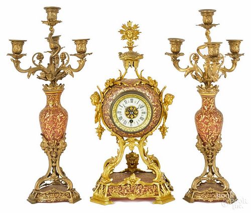 Gilt bronze and frosted ruby glass three-piece clock garniture set, early 20th c., with works