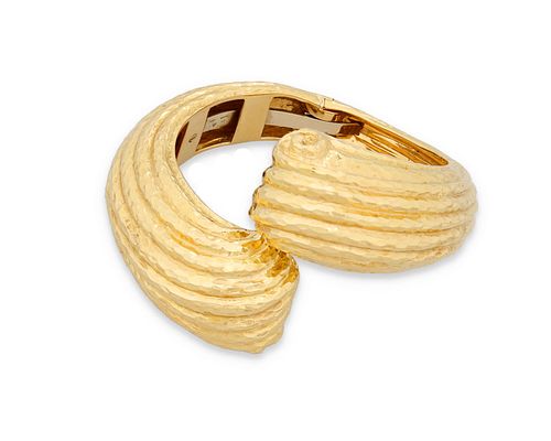A yellow gold hinged bangle bracelet