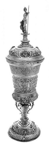 A German Silver Pokal, Hanau, Late 19th Century, surmounted by an armored warrior and worked throughout with repousse masks and
