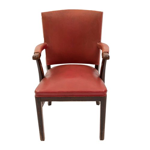 SILLÓN. SXX. Elaborado en madera. Con tapicería de piel color rojo. Respaldo cerrado, asiento acojinado, chambrana en "H".