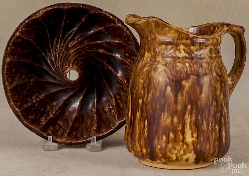 Two Bennington type pitchers, 19th c., 7'' h. and 9 1/2'' h., together with a food mold, 7 1/4'' dia.
