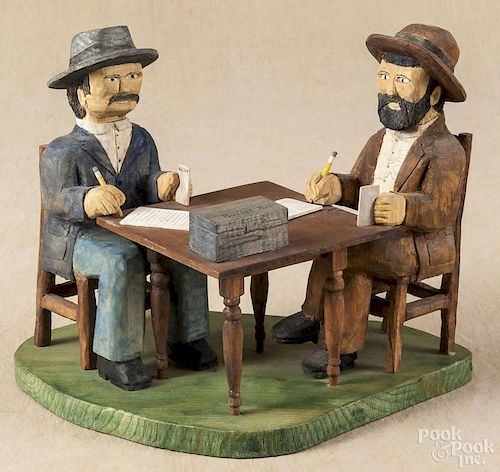 Roy Pace, carved and painted outsider art figures, seated at a table with a ballot box